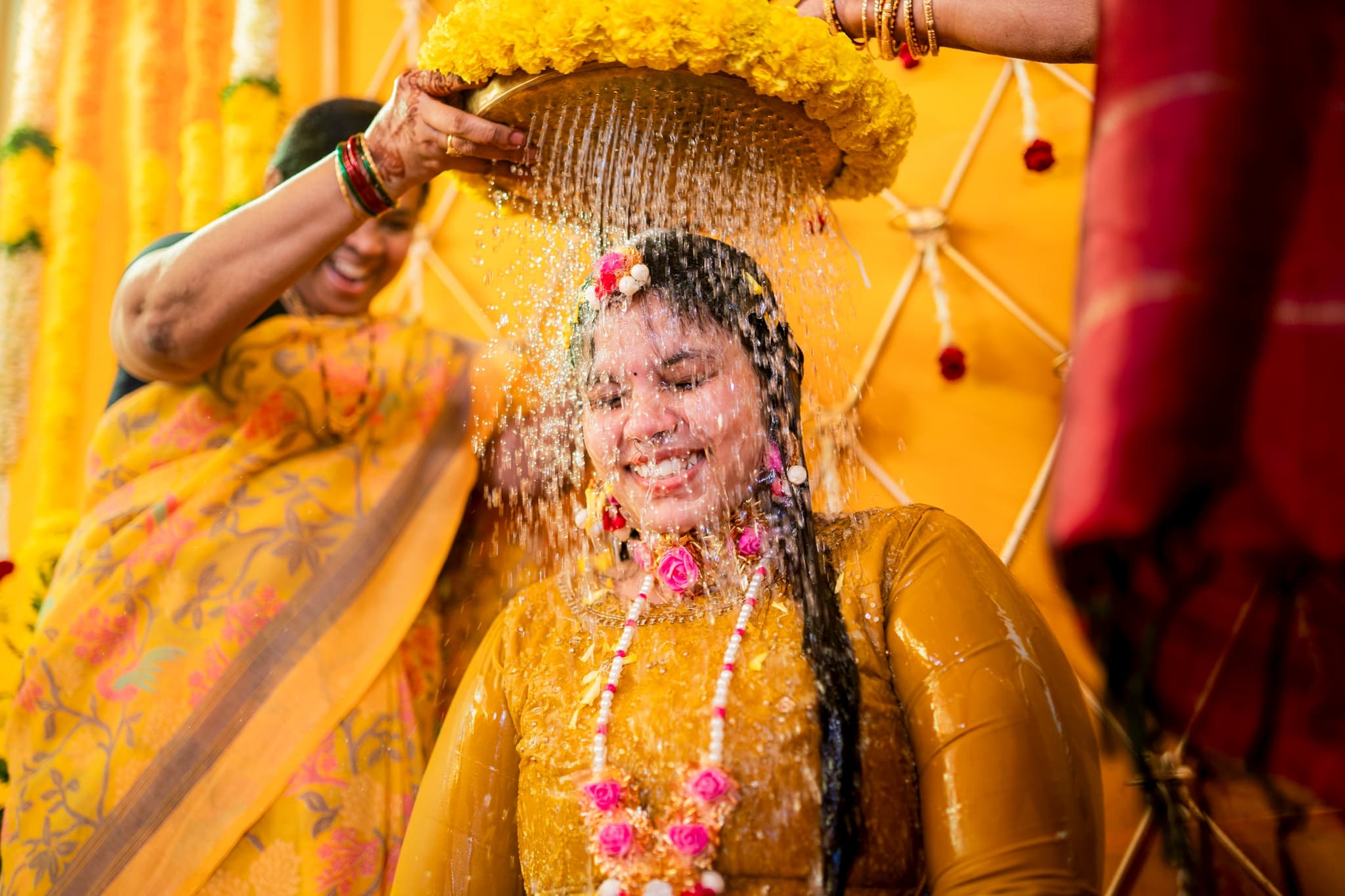 Haldi Ceremony Photography - Bride with water being poured during ritual