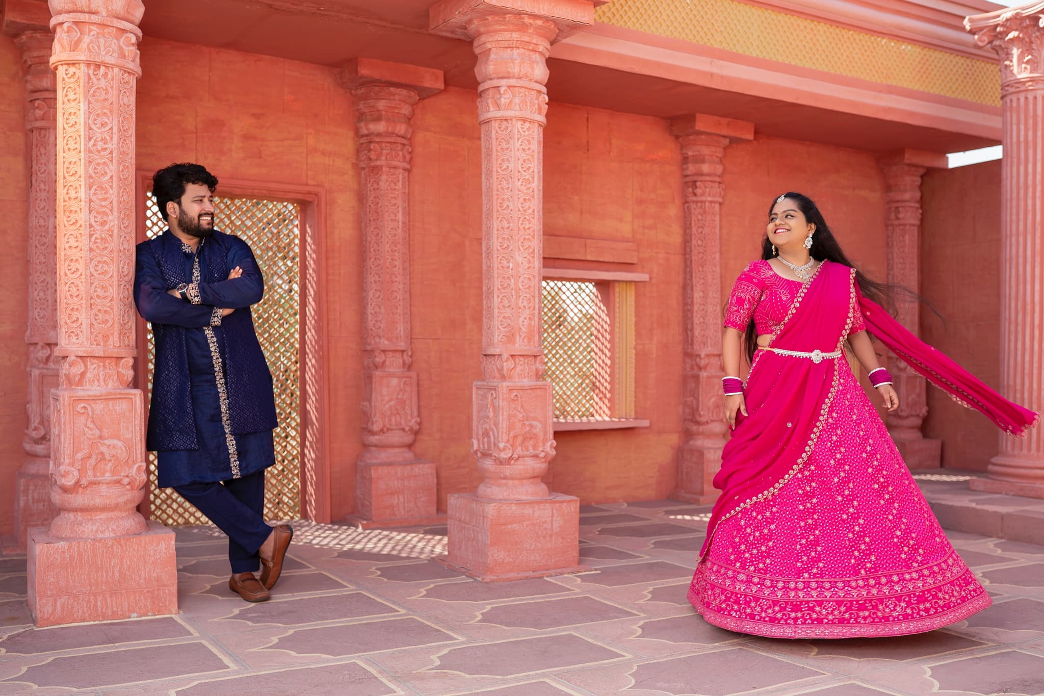 Couple in traditional attire dancing during sangeet celebrations